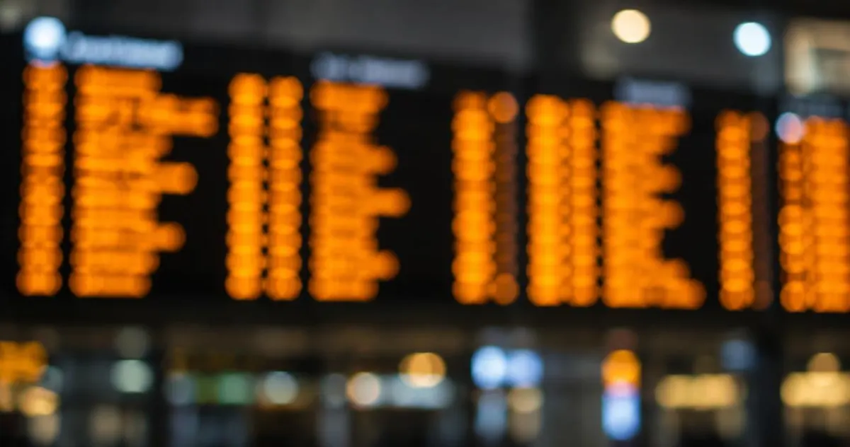 Onscherp vertrekbord met oranje regels in een stationshal